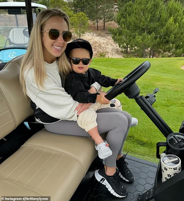 Bronzey, 18 months, posed with a pair of sunglasses in a golf cart with her mother.