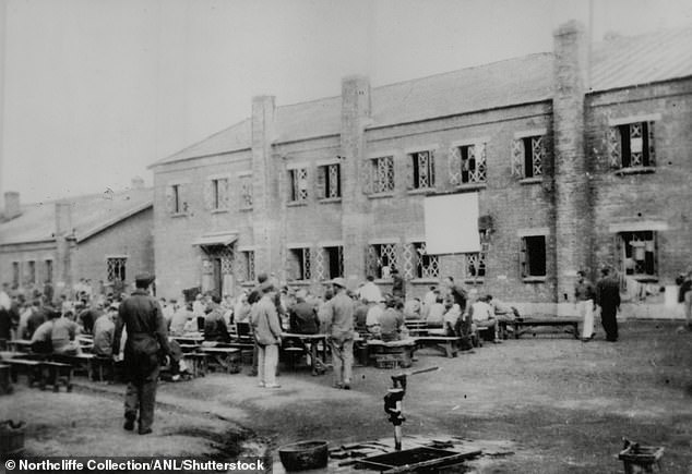 The image shows the inmates, known as 'maruta', which means logs, and the guards at the extermination camp.