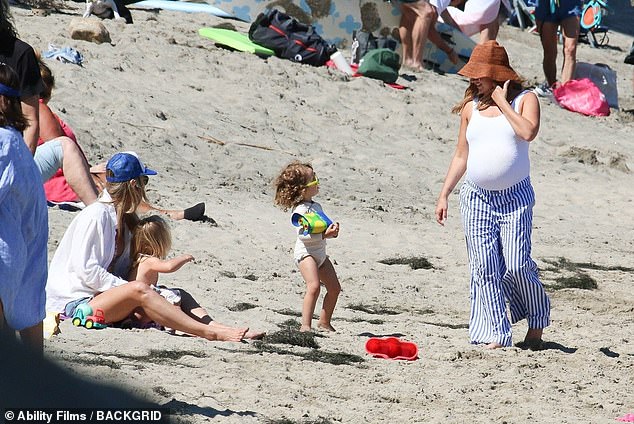 The actress, 38, who is expecting her second child with husband Christopher French, enjoyed playing in the sand with her three-year-old daughter Jupiter.