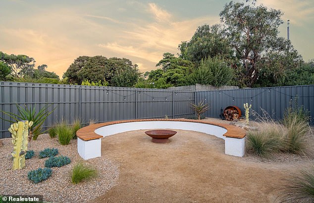 The backyard consists of a modern fireplace with a curved bench.