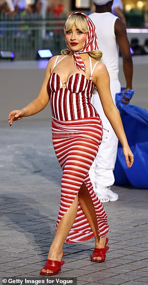 Sabrina Carpenter, 25, looked at home on the runway as she wowed in a red and white striped Jacquemus ensemble and matching headscarf.