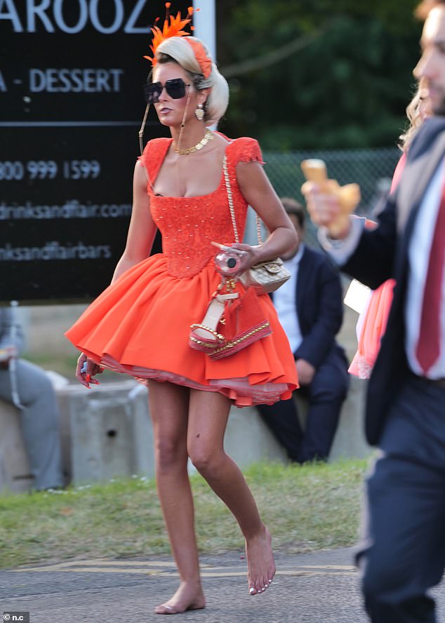 Elsewhere, another racegoer was seen wearing a stunning bright orange ensemble, which she teamed with a matching headpiece.