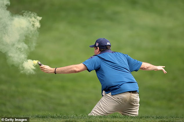 The street invaders, who appeared to be wearing messages about climate change on their T-shirts, threw red, white and yellow dust onto the golf course.