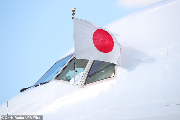 The Emperor's private plane flies the country's national flag out of the cockpit window as the plane stops on the runway at Stansted.