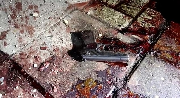 A police pistol is seen lying on a blood-stained sidewalk in Dagestan after the attacks.