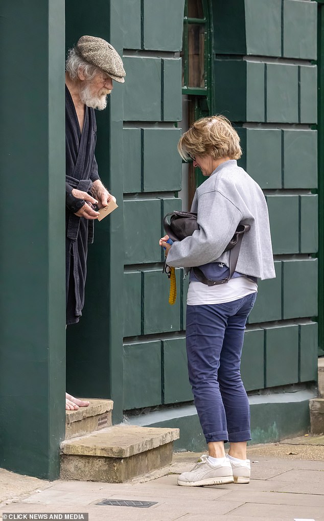 Sir Ian McKellen greets friend who arrived at his home in London yesterday