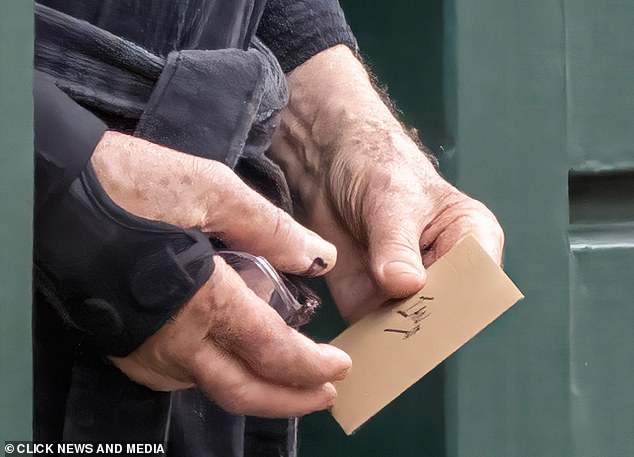 Sir Ian McKellen holds a card with 