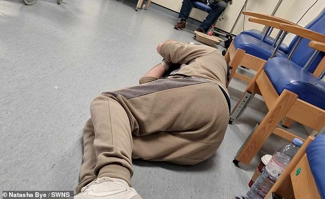 Pictured: A man sleeps on the floor in A&E while waiting 45 hours for a bed at William Harvey Hospital in Ashford, Kent.