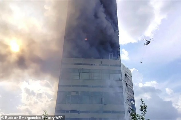 Firefighters work to put out a large fire in a high-rise building in the town of Fryazino, Moscow Region.