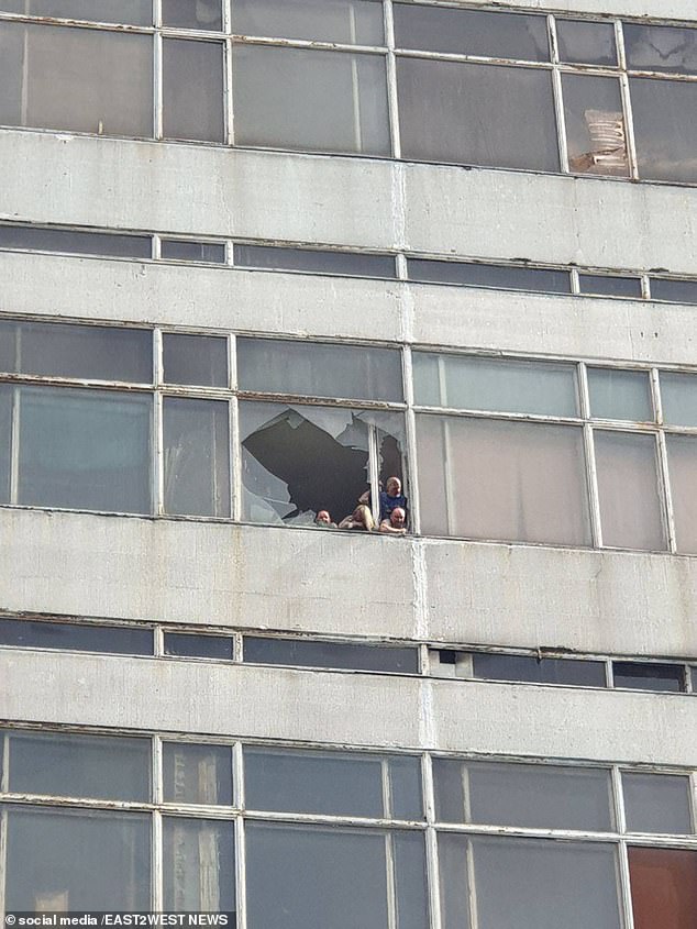 Chilling images appear to show workers looking helplessly through a broken window