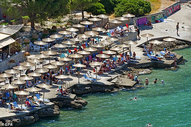 People try to stay cool at the seashore in the coastal area of ​​Arvanitia, Nafplio, Peloponnese, Greece, June 21, 2024.