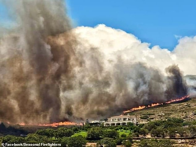 Smoke rises over a forest fire near a villa on the island of Andros in a photograph taken last week.