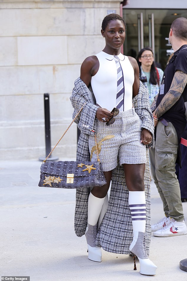 She put on a leggy display in a pair of extravagant white lace-up knee-high boots and carried her belongings in a black bag.