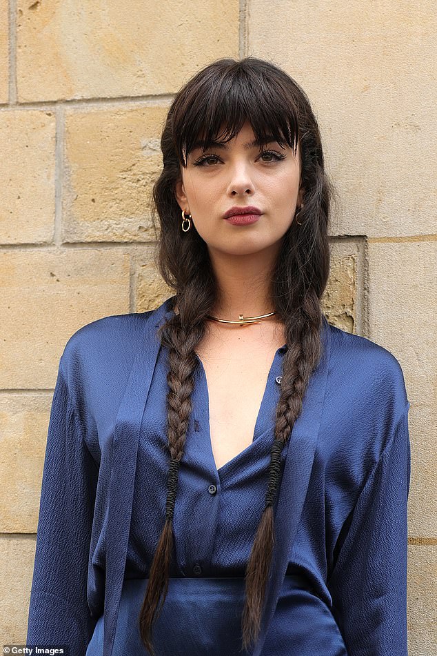 She wore her long brown locks in braids and accessorized them with gold earrings, a chunky choker, and a ring.