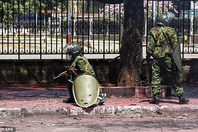 Kenyan riot police operate near the country's parliament during a protest against proposed tax increases.