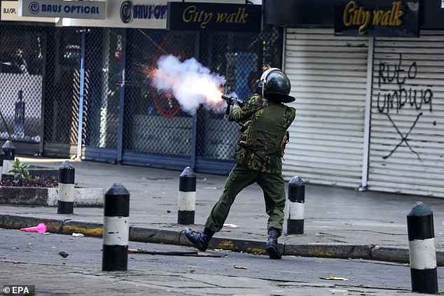 A police officer fires tear gas at protesters during a protest against proposed tax increases.