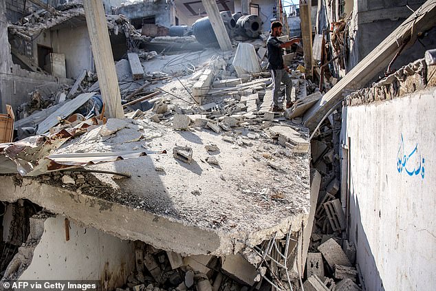 A man stands in the rubble of Ismail Haniyeh's sister's house after it was razed by Israeli shelling.