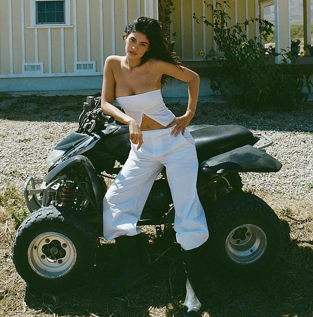 Jenner posed next to an all-terrain vehicle with a yellow house in the background.