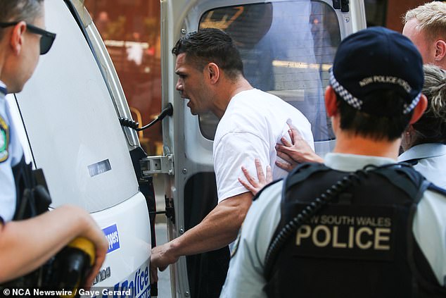 The former Rabbitohs and Panthers star is pictured being led to a police van after a court appearance for breaching the AVO in October last year.