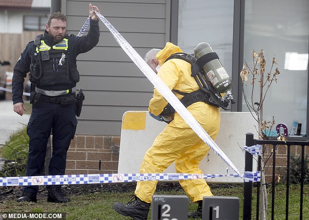 Officers donned protective suits and oxygen tanks as they entered the property Tuesday.