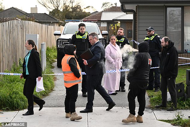 Family members, detectives and agents are seen outside the home on Tuesday.