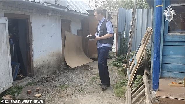 Laptops and disks with pornographic content were confiscated from the house. In the photo an investigator appears searching the property.