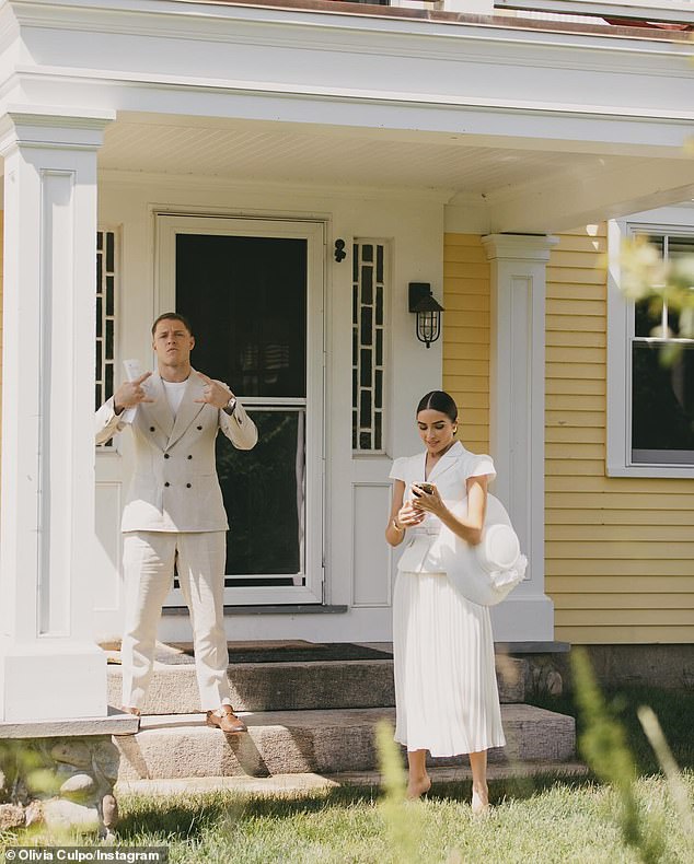 Christian motioned with his hands as his beloved looked at her cell phone while holding a wide-brimmed hat under her arm.