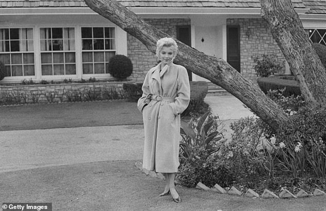 Monroe poses outside her home in 1962, it was the only property she ever bought and owned.