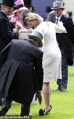 The royal tried to keep her balance as a man rushed to help and made sure the shoe was securely back on her foot.