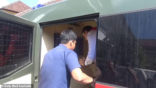 Troy Smith (in white shirt) is pictured getting out of a prison van in Bali on Thursday.