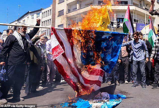 Protesters burn an American and an Israeli flag during the funeral of seven members of the Islamic Revolutionary Guard Corps killed in an attack in Syria.