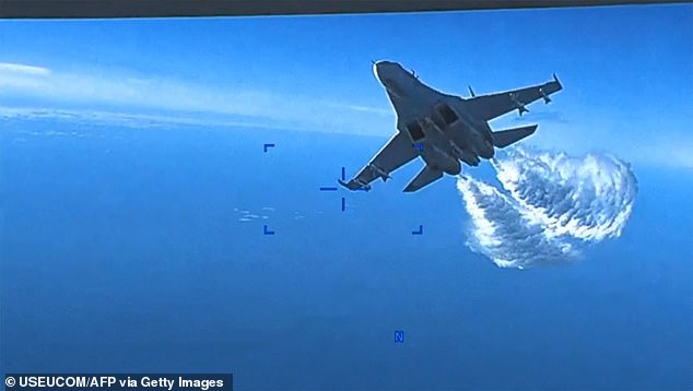 This image taken from a video released by US European Command (USEUCOM) on March 16, 2023, shows footage aboard a US Air Force MQ-9 drone when a Russian SU- 27 approaches it for the first time, dropping fuel, over the Black Sea on March 14, 2023.