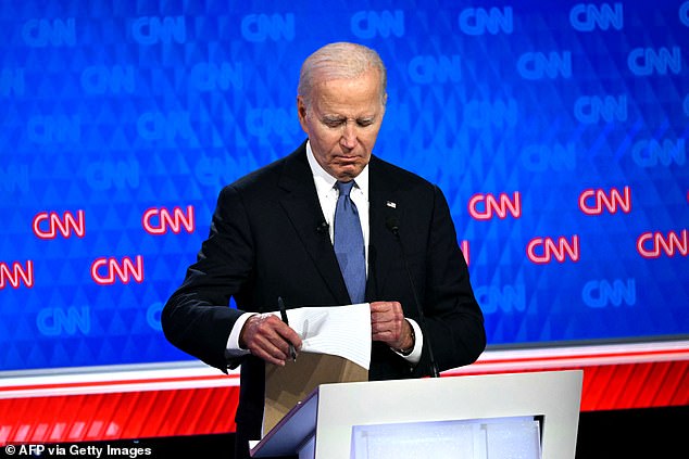 At times, President Biden stared into the camera or looked at his notes (pictured) as Trump spoke.