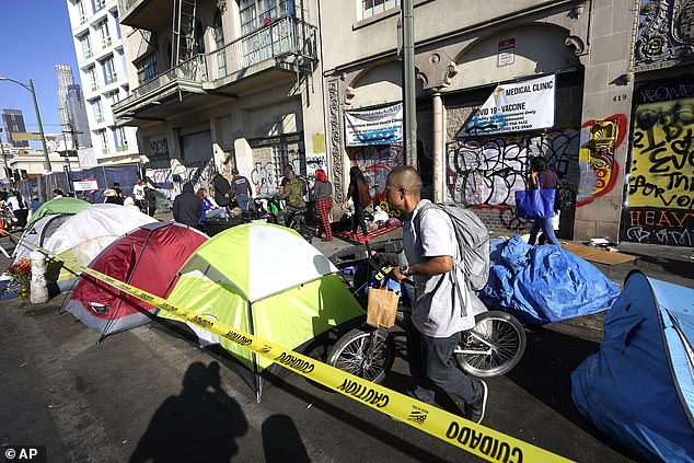 People line up next to temporary tents to participate in a free Thanksgiving meal provided by Union Rescue Mission on Los Angeles Skid Row.