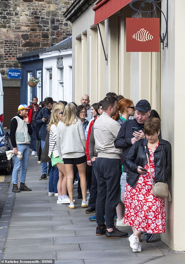 Customers keep busy as they queue outside Lannan Bakery in Edinburgh's Stockbridge area