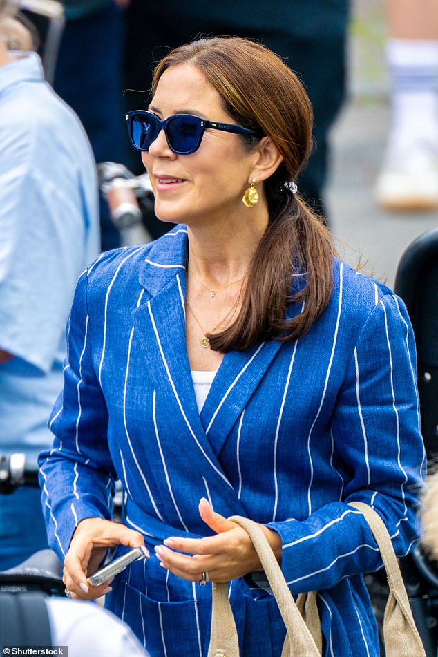 Mary looked chic in a blue double-breasted blazer with white stripes and wayfarer sunglasses as she watched the procession.