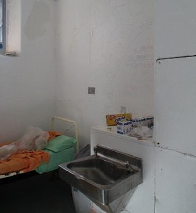 A cell in Wandsworth with graffiti scrawled on the stained walls