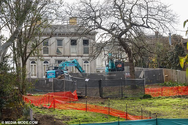 Out front are stands of equipment, including a bulldozer and a trailer to transport the garbage collected at the mansion.