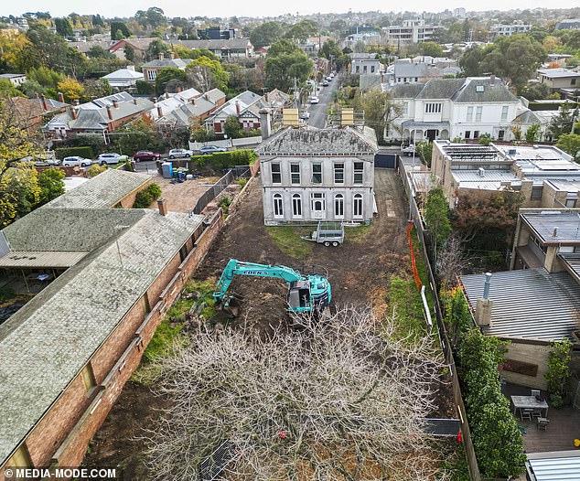 Fences are being erected around the property as work continues, with barren trees and shrubs cordoned off.