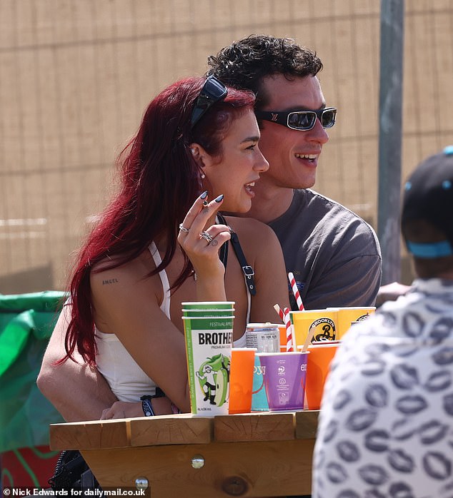 The couple chatted and mingled with friends as they sat on a beach at the festival.