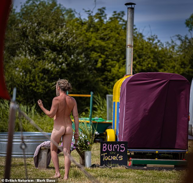 A Nudefest attendee walks past a sign that says 