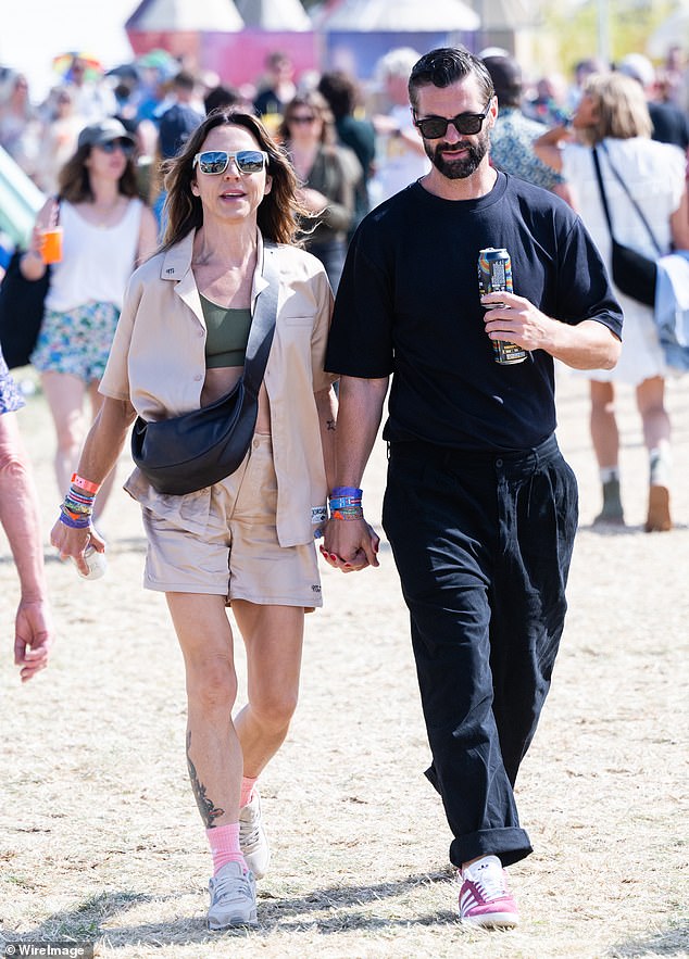 The couple looked happier than ever as they held hands and carried drinks in the other as they toured the iconic Worthy Farm.