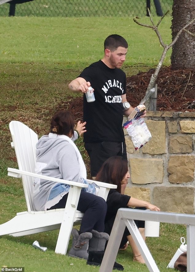 Nick Jonas, 31, showed off a relaxed look in a black Miracle Academy t-shirt and black shorts.