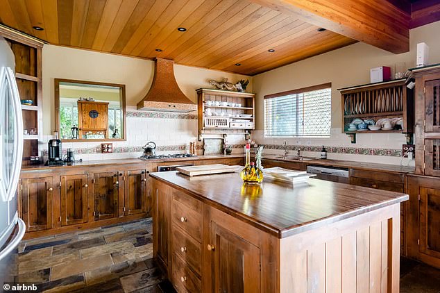 A huge, nostalgic country kitchen clad in warm wood panelling.