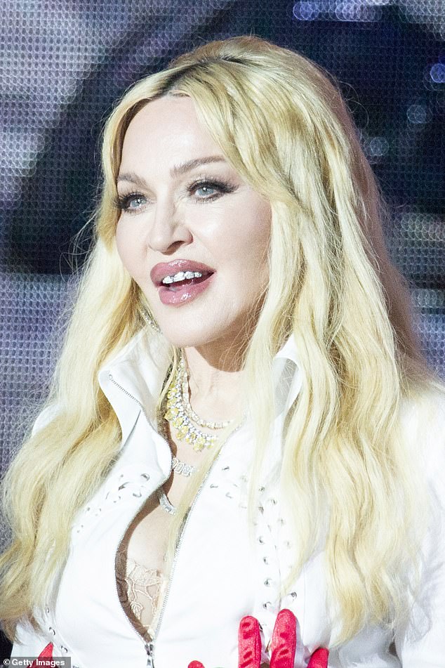 Madonna completed the look with sparkling jewel necklaces dangling from her cleavage, as well as a diamond grille across her mouth.