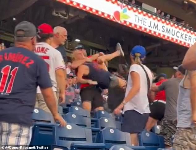 A fan is removed after exchanging blows with another woman in the stands.