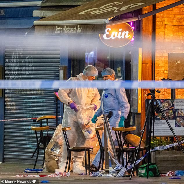 Pictured: Forensic officers gather evidence at the scene in Dalston, east London.