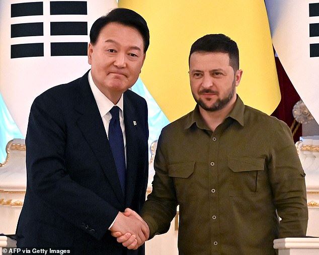 Ukrainian President Volodymyr Zelensky and his South Korean counterpart Yoon Suk Yeol shake hands following their remarks following talks in kyiv on July 15, 2023.