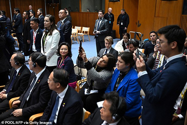 Lei (looking to his left) then swapped seats with the woman in the blue jacket.