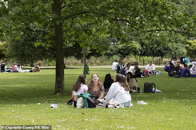 People relaxing in the warm weather in St James's Park in London